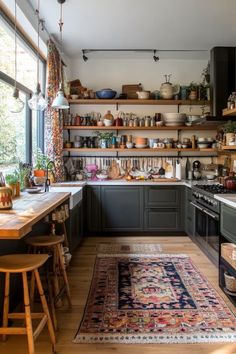 a kitchen filled with lots of counter top space next to a large rug on the floor