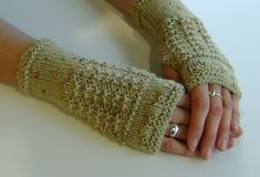 two hands are holding each other while wearing knitted fingerless mittens and gloves