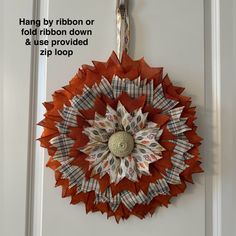 an origami sunflower hanging on a door with the words hang by ribbon or fold ribbon down and use provided zip loop