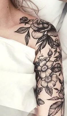 a woman's arm with flowers and leaves on it