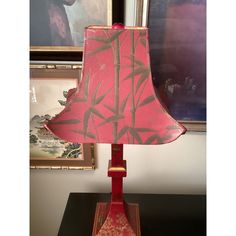 a lamp that is sitting on top of a wooden table in front of a painting