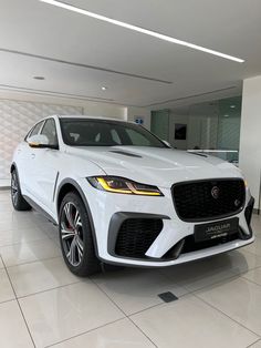 a white car is parked in a showroom