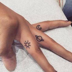 two hands with tattoos on them are sitting next to each other, one has a sun and the other is a crescent