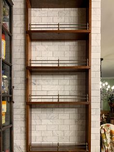 an empty shelf in the corner of a room next to a wall with shelves on it