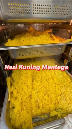 two trays filled with yellow rice sitting on top of each other