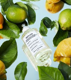 a bottle of replicac surrounded by lemons and limes on a blue background