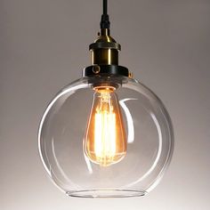 a clear glass light bulb hanging from a ceiling fixture with a black cord attached to it