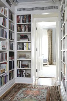 an image of a room with bookshelves and rugs on the floor in front of it