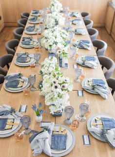 the table is set with blue and white dishes, napkins, and silverware