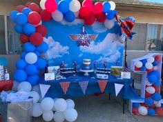 a table with balloons, cake and decorations on it