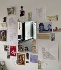 a white wall covered in pictures and magnets next to a window with a mirror on it