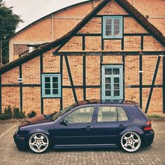 a blue car parked in front of a brick building