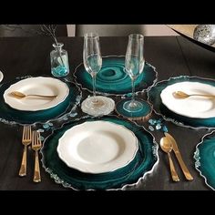 a table set with plates, silverware and wine glasses