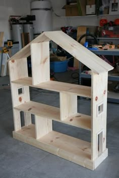 a house made out of wood sitting on top of a cement floor in a garage