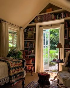 a living room filled with furniture and bookshelves next to an open door that leads to a patio