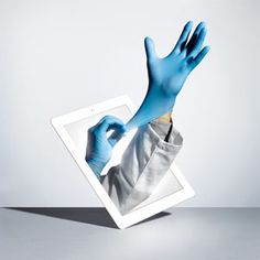 a person in blue gloves is holding an ipad