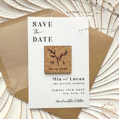 save the date magnets are on top of some brown envelopes and white paper