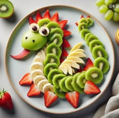 a plate topped with sliced kiwis and strawberries on top of a table