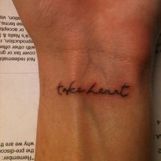 a small wrist tattoo that says the heart