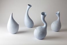 three white vases sitting next to each other