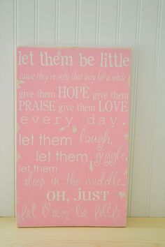 a pink and white sign with words written on it that says let them be little