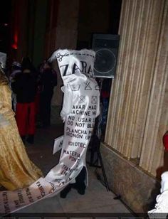 a woman dressed in costume standing next to a column