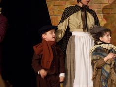 three children dressed in period costumes standing next to each other