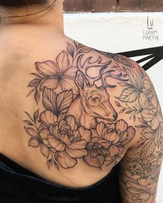 the back of a woman's shoulder with flowers and a deer