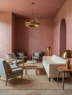 a living room filled with furniture and pink walls