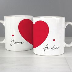 two white coffee mugs with red hearts and names on them, one has the word amalia written in black ink