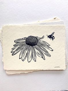 a piece of paper with a drawing of a sunflower and a bee on it