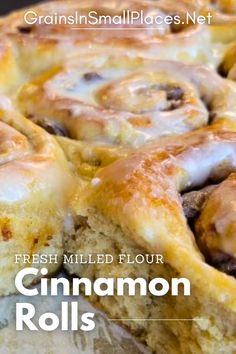 a close up of cinnamon rolls on a plate with text overlay that reads, fresh milled flour cinnamon rolls