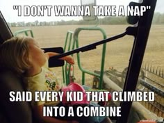 a little boy sitting in the driver's seat of a tractor looking at something