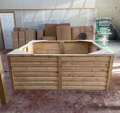 a large wooden box sitting in the middle of a room with boxes on the floor