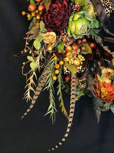 an arrangement of flowers and foliage on a black background with leopard print ribbon in the center