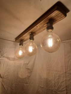 three light bulbs are hanging from the ceiling