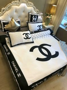 a bed with black and white pillows, chandelier and pillow cases on it