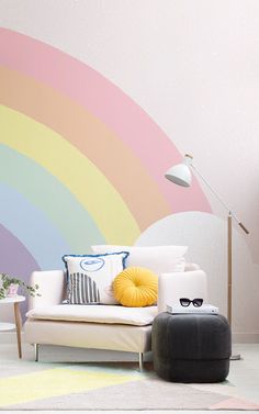 a living room with a rainbow painted wall behind the couch and floor lamp next to it