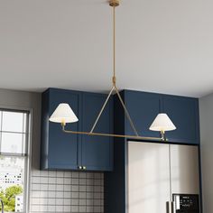 a kitchen with blue cabinets and a gold chandelier hanging from the ceiling over an island