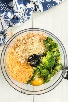 broccoli, cheese and other ingredients in a blender on a white table