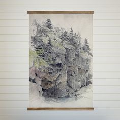 a painting hanging on the wall next to a wooden framed artwork piece with trees growing out of it