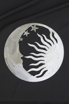 a black shirt with white stars and a crescent moon on the front, as well as an image of a woman's face