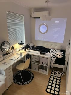 a bedroom with a bed, desk and projector screen on the wall above it