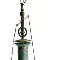 an old fashioned oil lamp with chains hanging from it