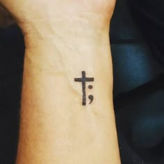 a person with a cross tattoo on their wrist