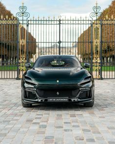 a black sports car parked in front of a gate