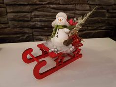 a small snowman sitting on top of a sled