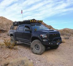 a black truck is parked in the desert