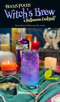 witches brew halloween cocktail with purple and blue liquid in a glass, surrounded by candles