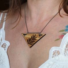 a close up of a woman wearing a necklace with an arrow design on the front